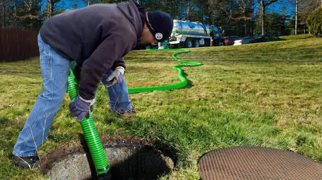 Service technician performing residential septic pumping and drainage maintenance in Raleigh, NC